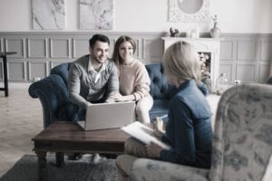 Wedding planner meeting with couple and explaining planning responsibilities